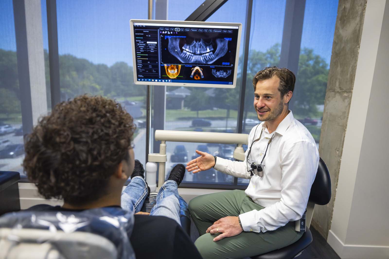 Dr. Shawn Custer talking to a dental patient at keith + associate dentistry implant center.