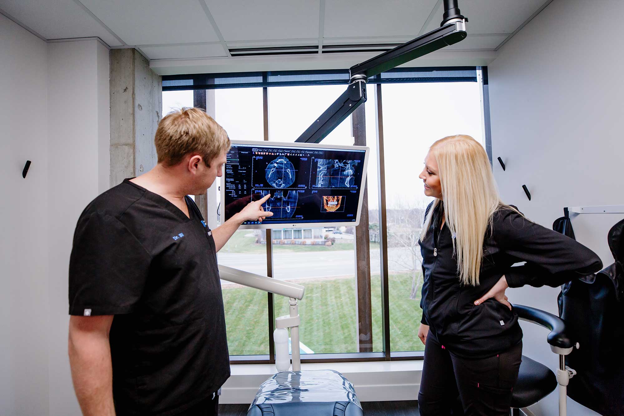 Dr. Bill Keith looking at dental x-rays with dental assistant.